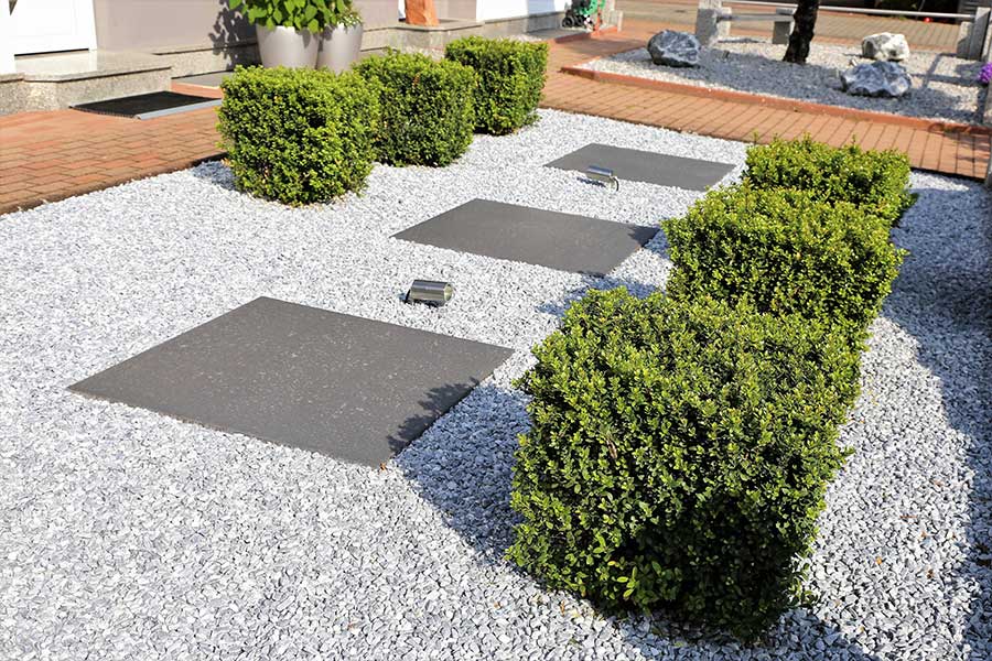 Decorative gravel used to control weeds in a large flower bed